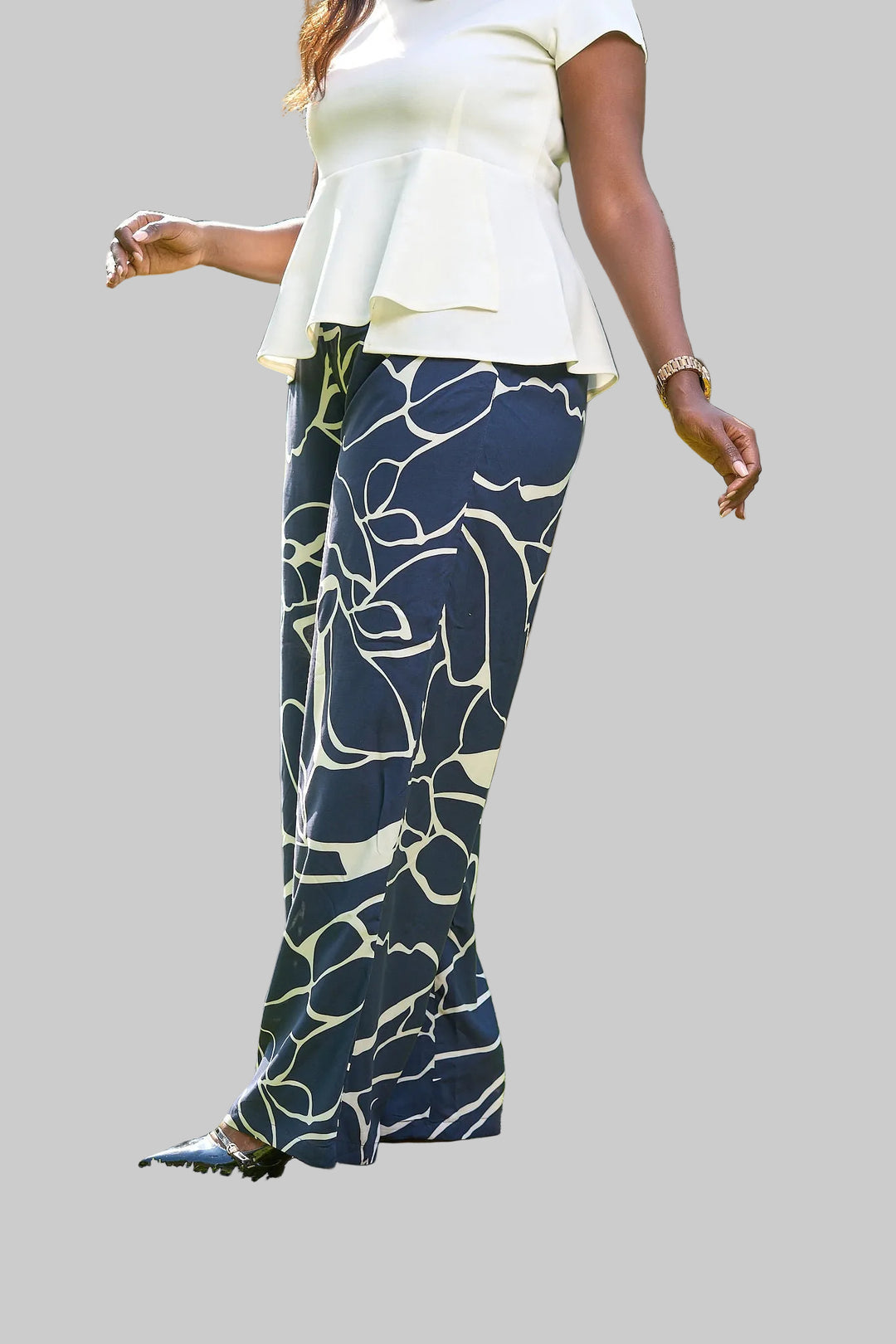 Person wearing navy blue pants with white patterns outdoors on a grassy area.