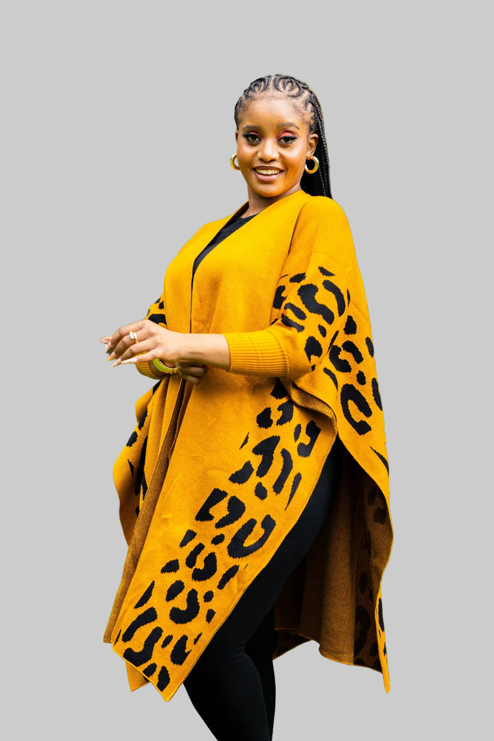 Woman wearing a mustard yellow cardigan with leopard print sleeves outdoors.