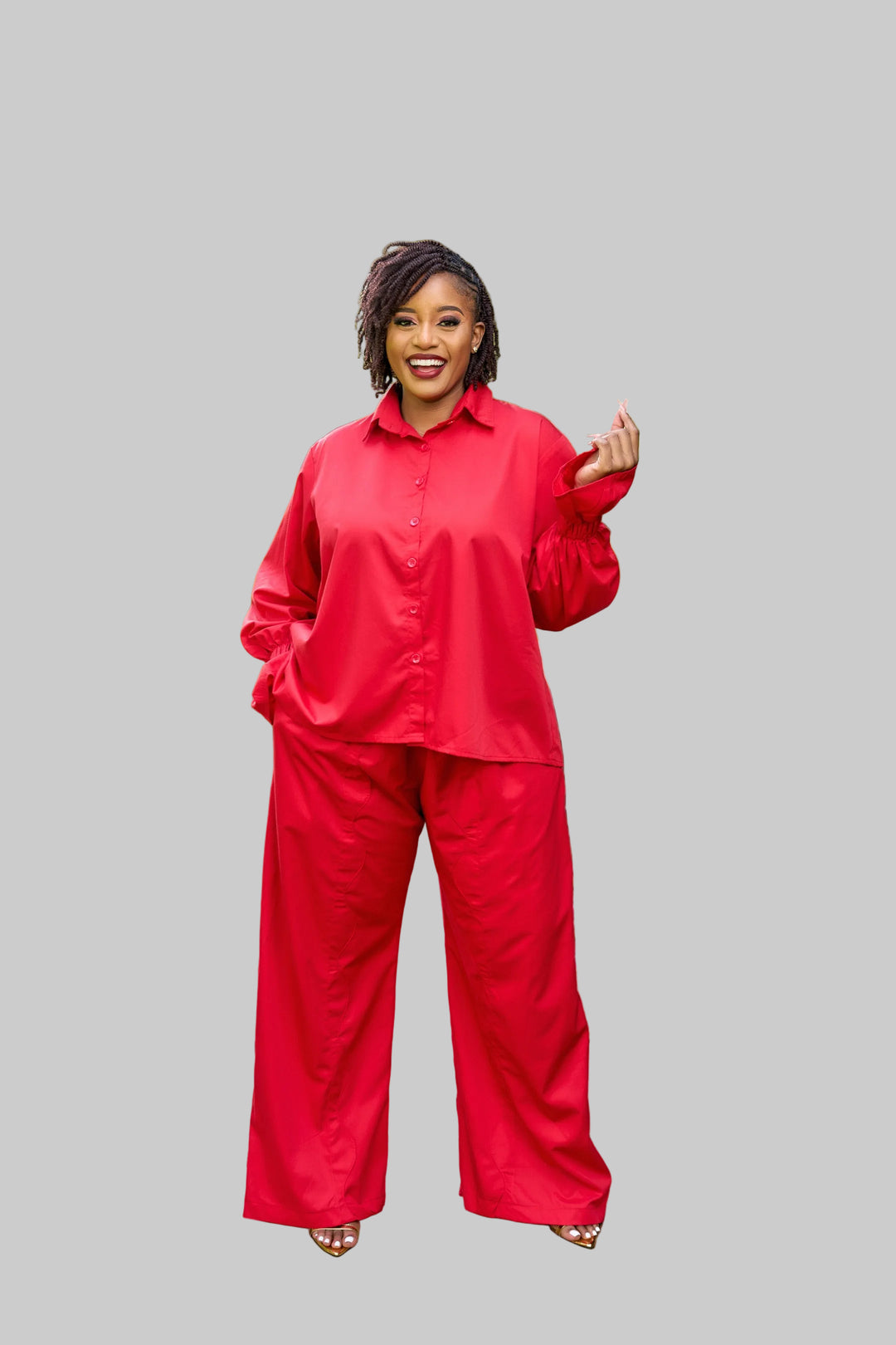 Woman in a red outfit standing on a stone path in a garden